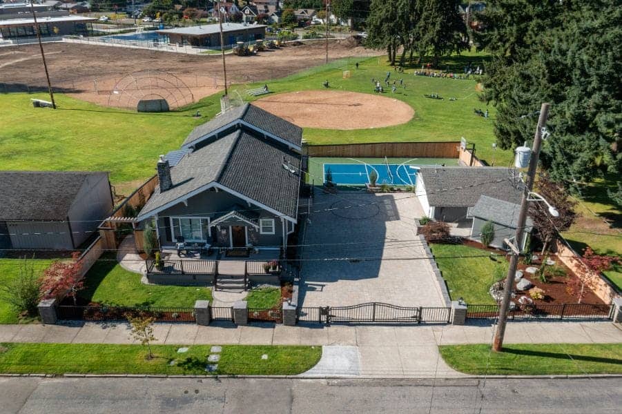 Composite deck with covered outdoor kitchen, sport court visible in the background, Fircrest