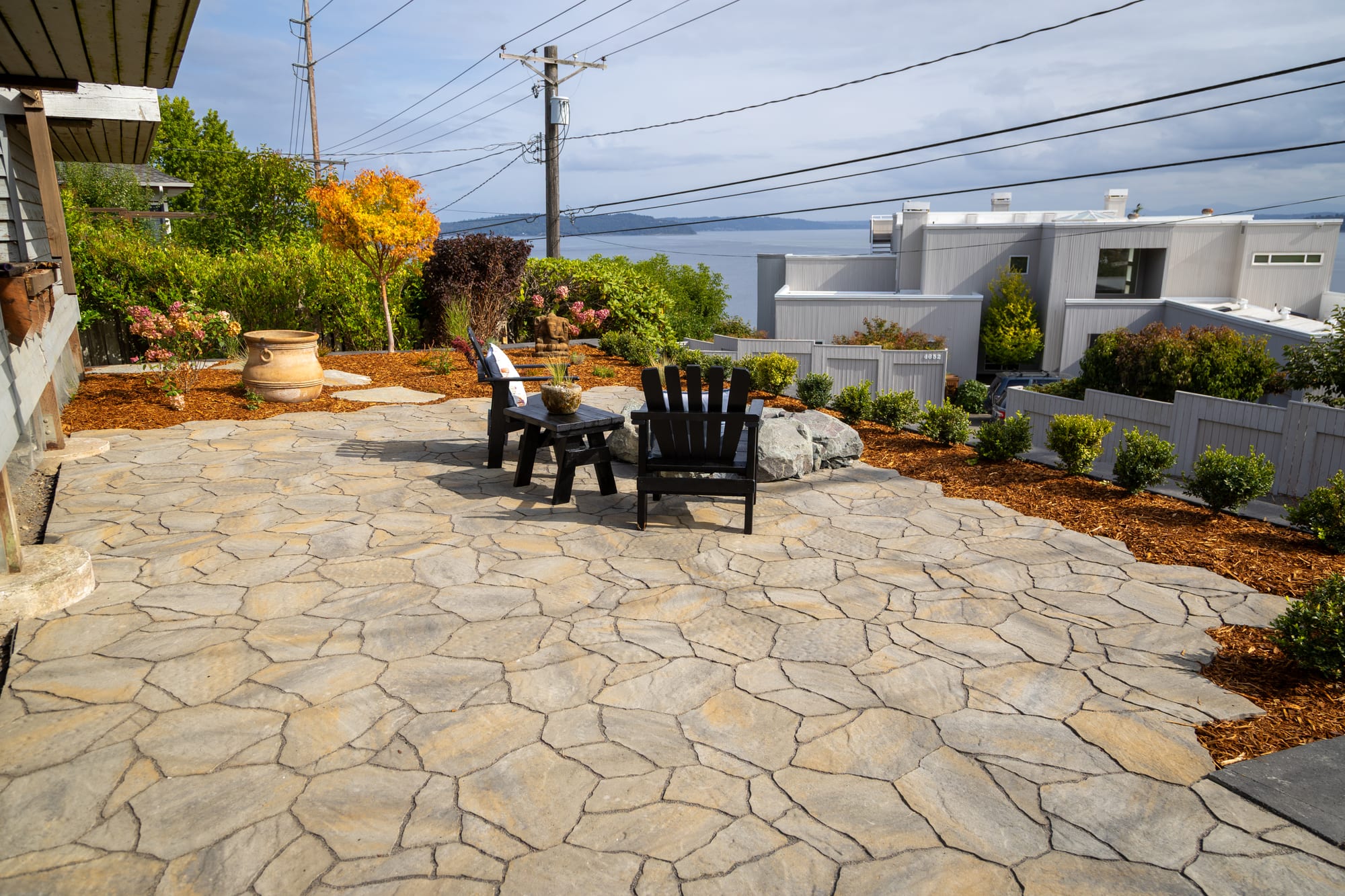 A wide view across the paver patio toward the neighborhood and the water